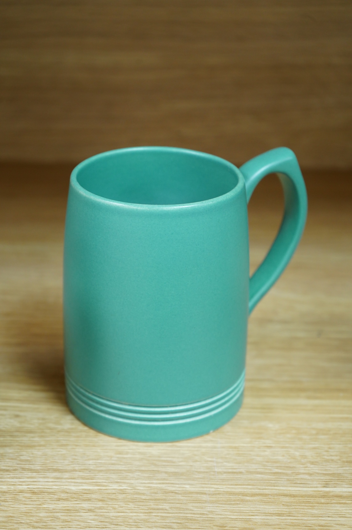 A pair of Keith Murray for Wedgwood green monochrome tankards, 12cm high